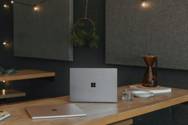 Surface laptops on a table at work with Christmas lights in the background